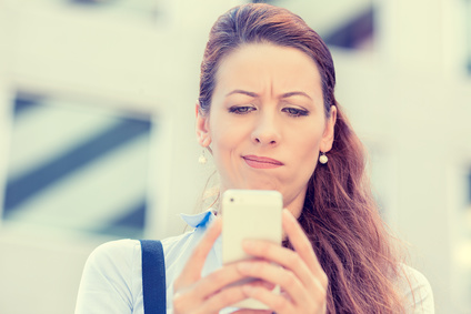 upset skeptical unhappy serious woman texting on mobile phone